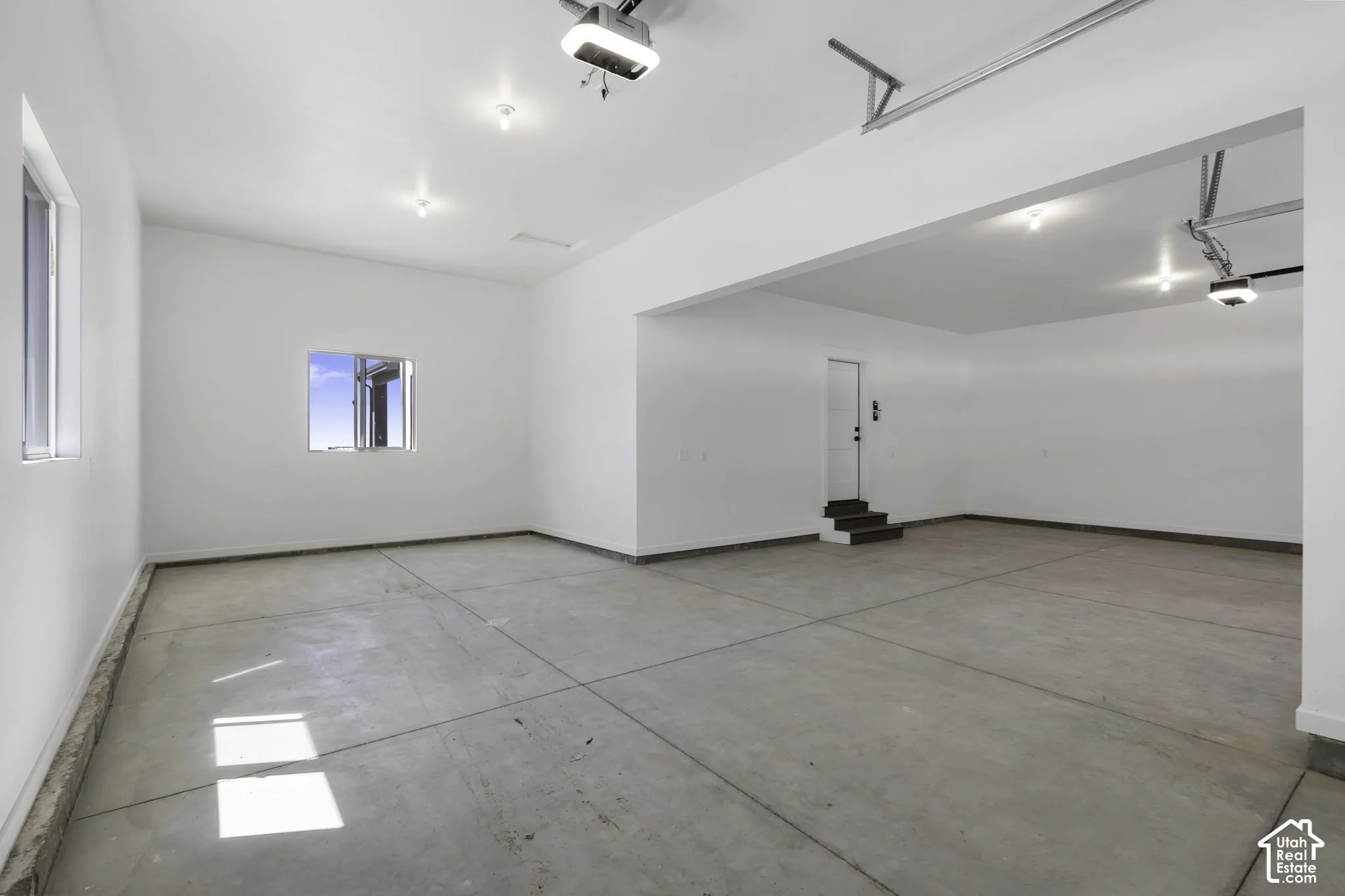 Spacious open floor plan with polished concrete flooring, recessed lighting throughout, and clean white walls