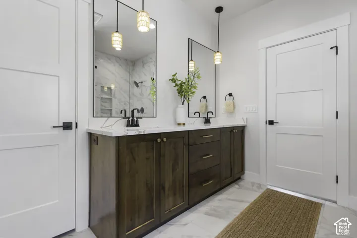 Dual vanity with wood-finish cabinetry, quartz countertops, and matte black fixtures
