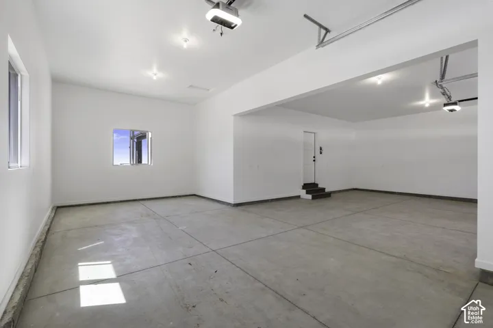 Spacious open floor plan with polished concrete flooring, recessed lighting throughout, and clean white walls