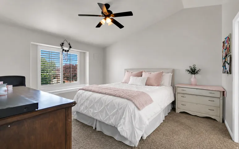 Carpeted flooring complemented by light-toned wall paint and an angled ceiling