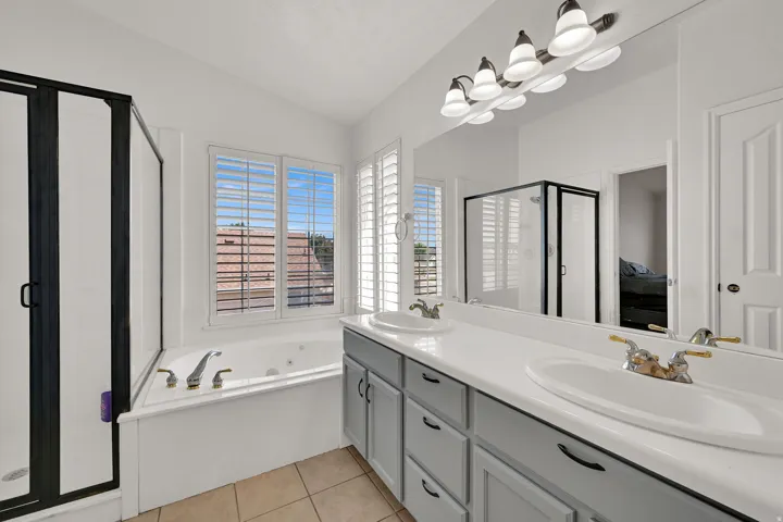 Dual vanity with undermount sinks, white countertop, and gray cabinetry