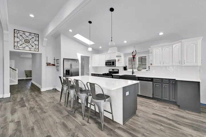 Kitchen featuring a central island, wood-finish flooring, recessed lighting, and a skylight