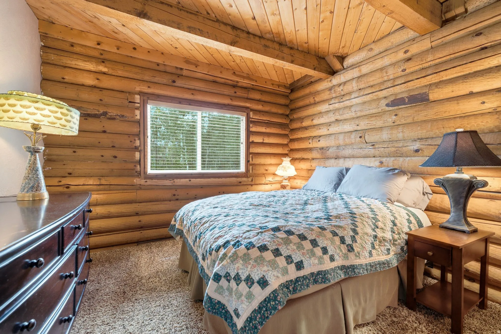 Log wall construction, wood-planked ceiling, and a window with blinds