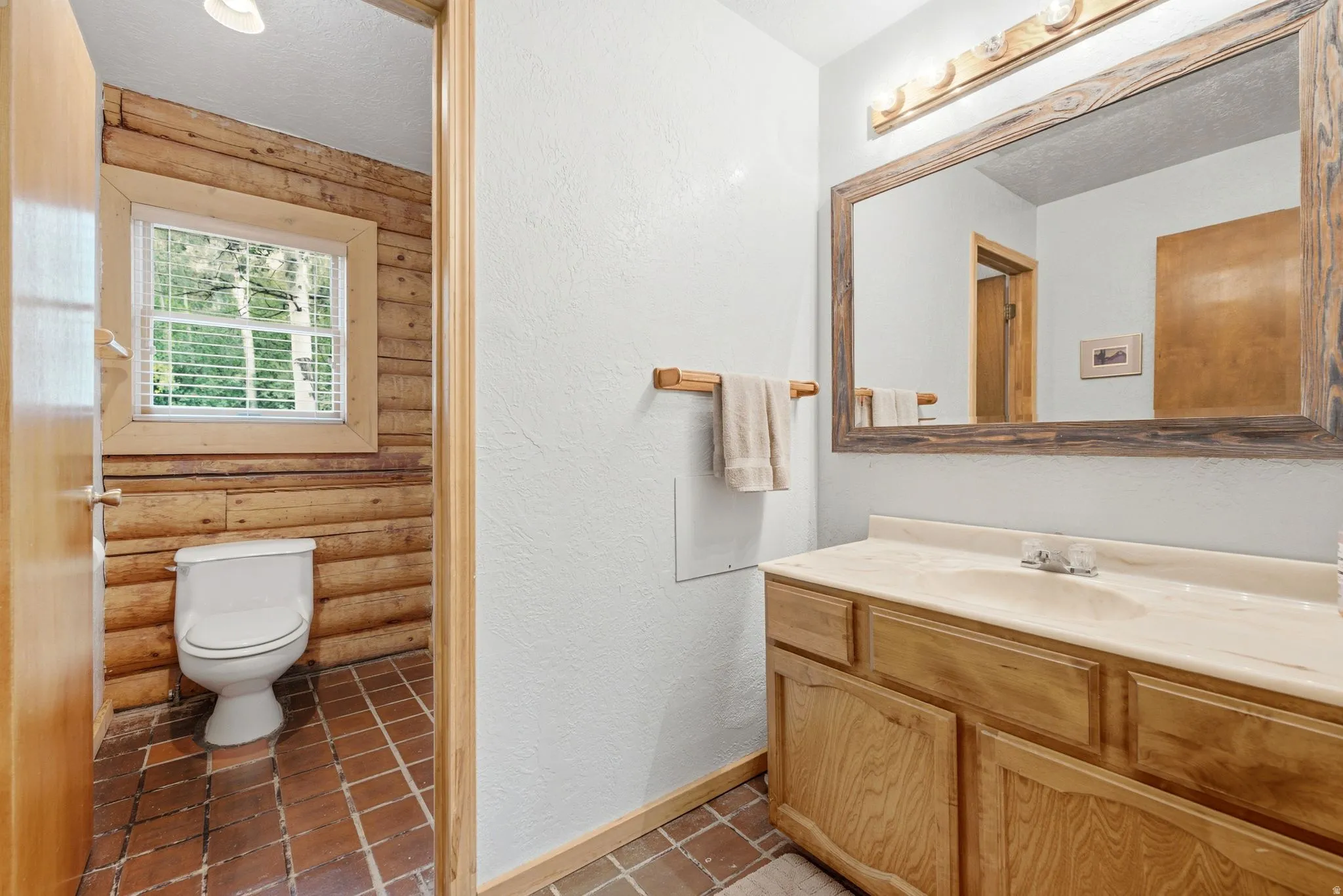 Wood-finish vanity with an integrated sink and a framed mirror