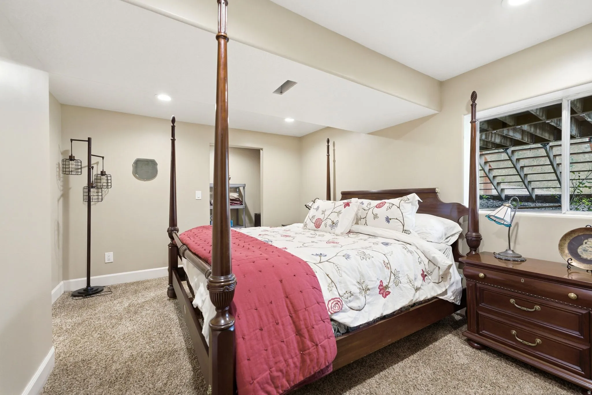 Recessed ceiling lighting, carpeting, and a window with a window well