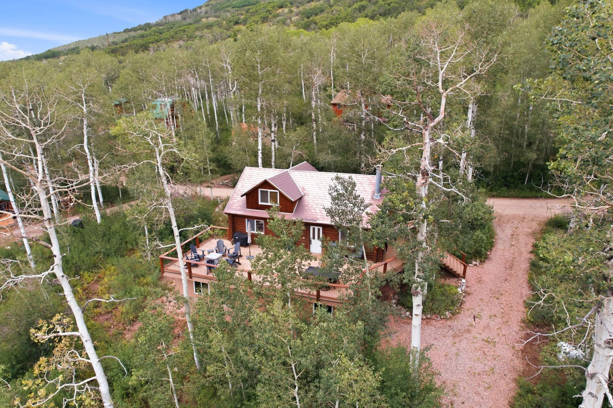 Wood-sided residence featuring an A-frame roof and an expansive wood deck
