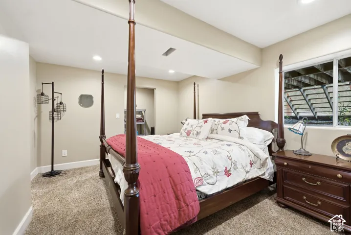 Recessed ceiling lighting, carpeting, and a window with a window well