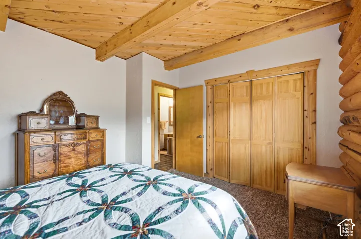 Exposed wood beam ceiling, natural wood paneling, and wood bi-fold closet doors