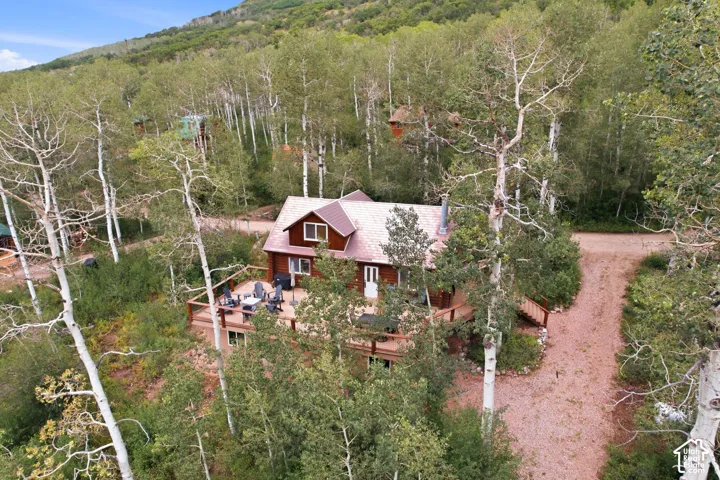 Wood-sided residence featuring an A-frame roof and an expansive wood deck