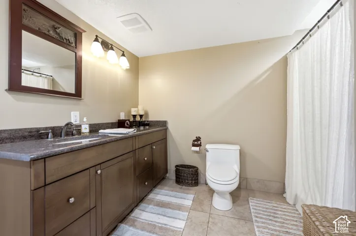 Extended vanity with an integrated sink, dark countertop, and wood-finish cabinetry