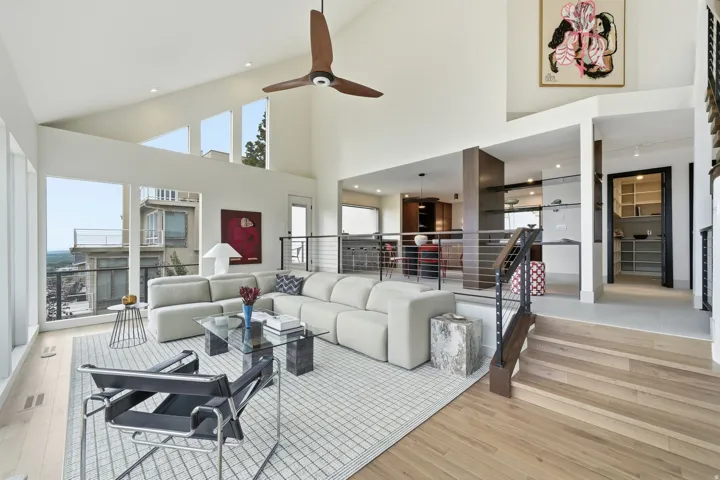 Vaulted ceilings with clerestory windows, light wood-finish flooring, and a contemporary cable railing system