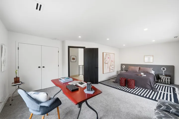 Recessed ceiling lighting, white walls, and a dark wood-finish door