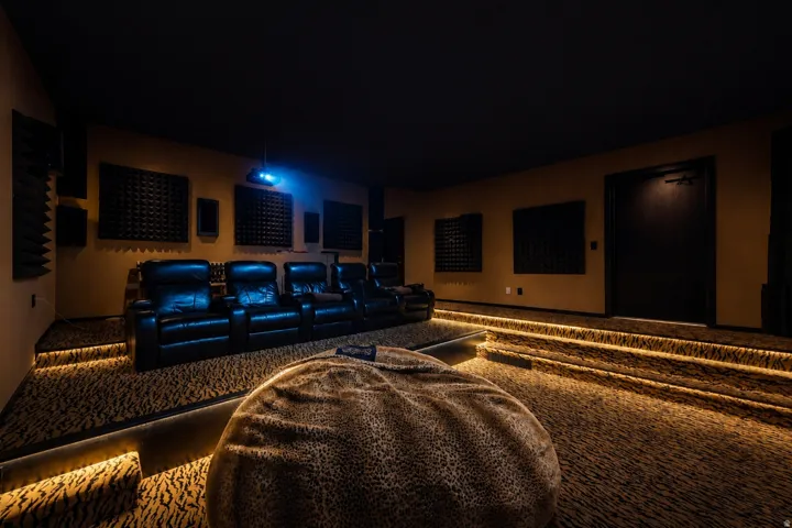 Dedicated media room featuring tiered seating, built-in ambient step lighting, and sound-absorbing wall panels