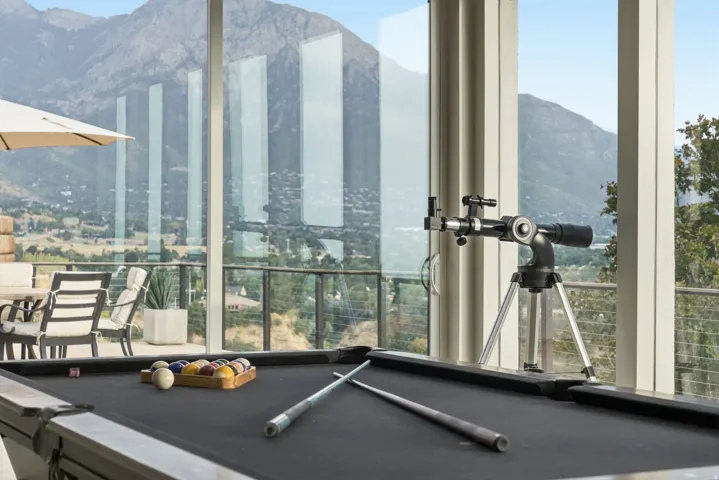 Expansive window wall overlooking mountainous terrain and distant cityscape