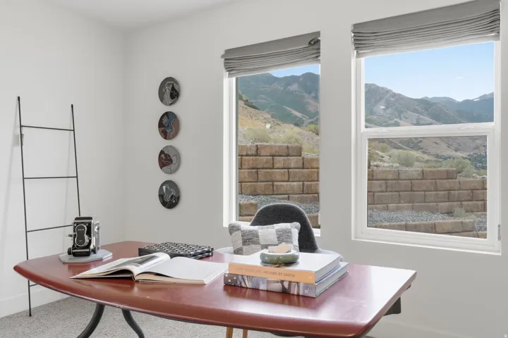 Dual windows with integrated window treatments, offering mountain scenery and natural light