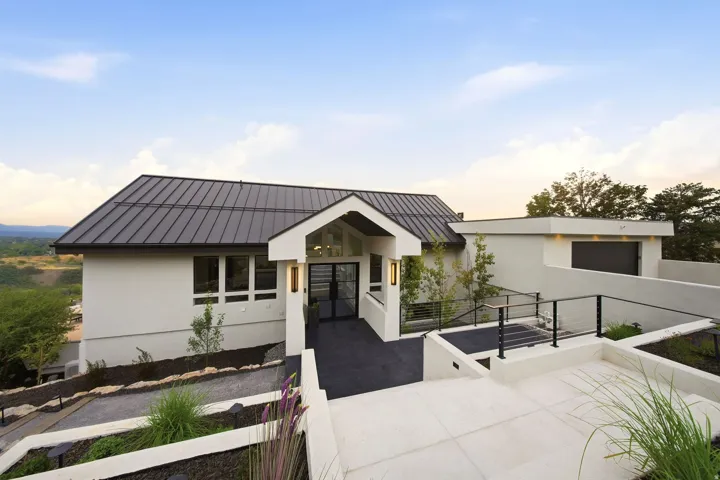 Contemporary exterior with a metal roof, stucco finish, and recessed windows