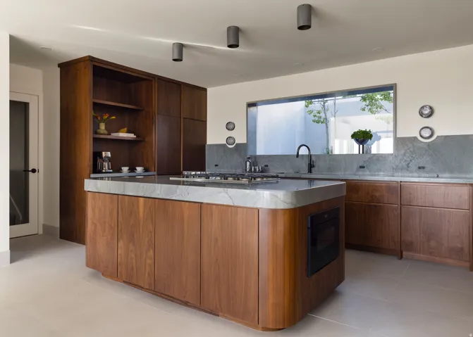Kitchen featuring a large center island, wood cabinetry, stone countertops with integrated backsplash, a gas range, and an integrated wall oven
