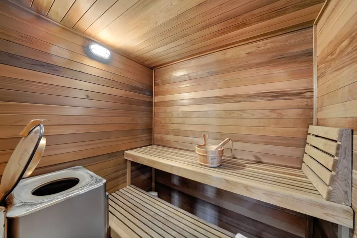 Wood-paneled walls and ceiling, built-in wooden benches, and wall-mounted lighting
