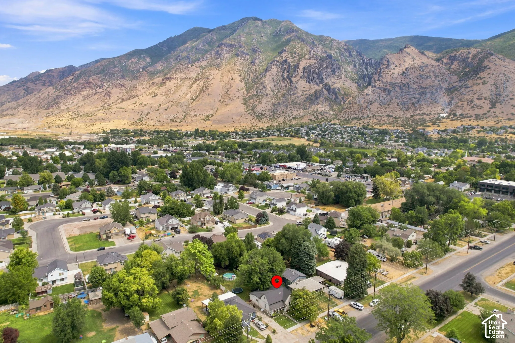 Aerial perspective showcasing the subject property, residential neighborhood, and prominent mountain backdrop