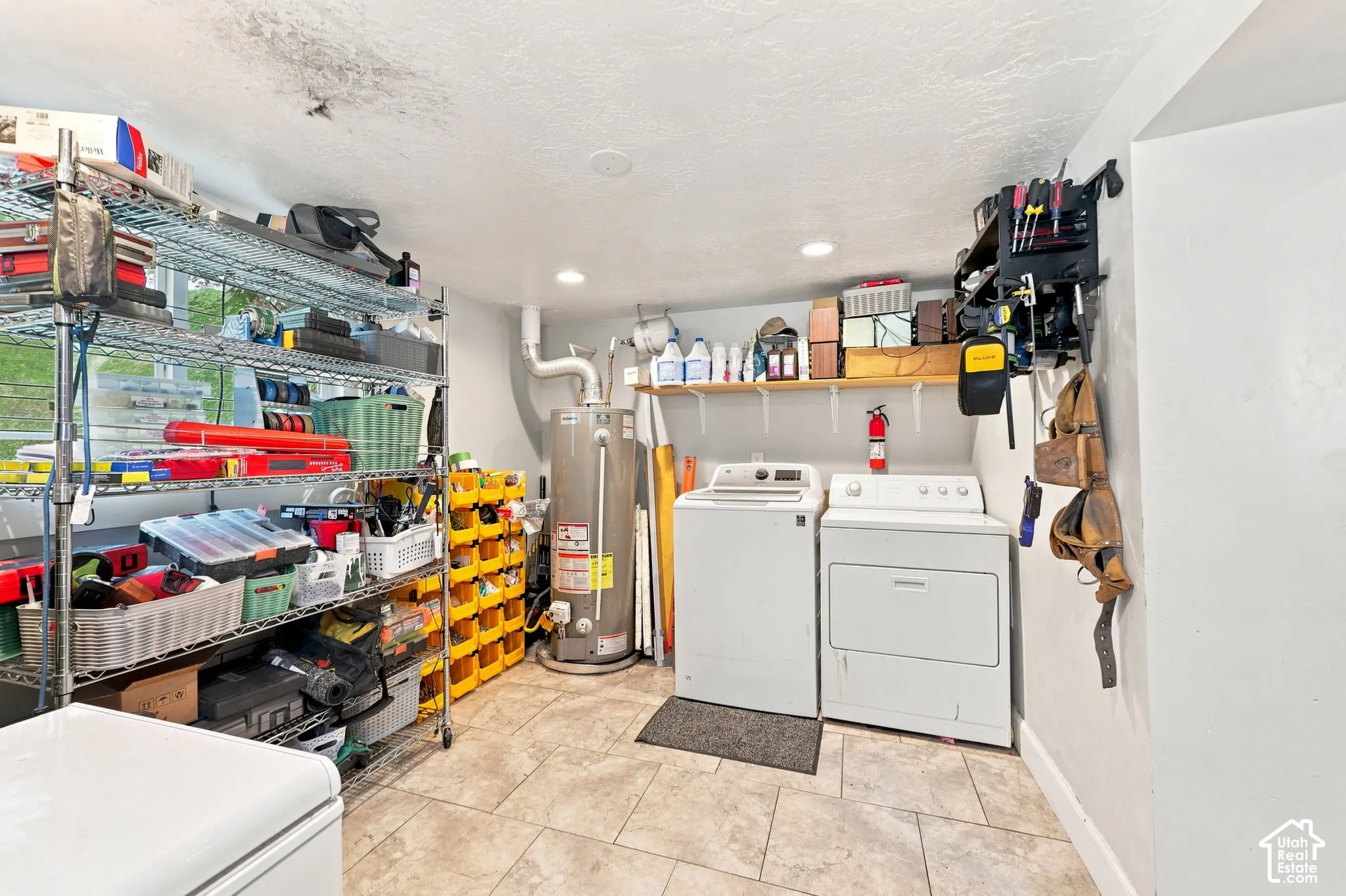 Laundry area featuring a washer and dryer, water heater, and tiled flooring