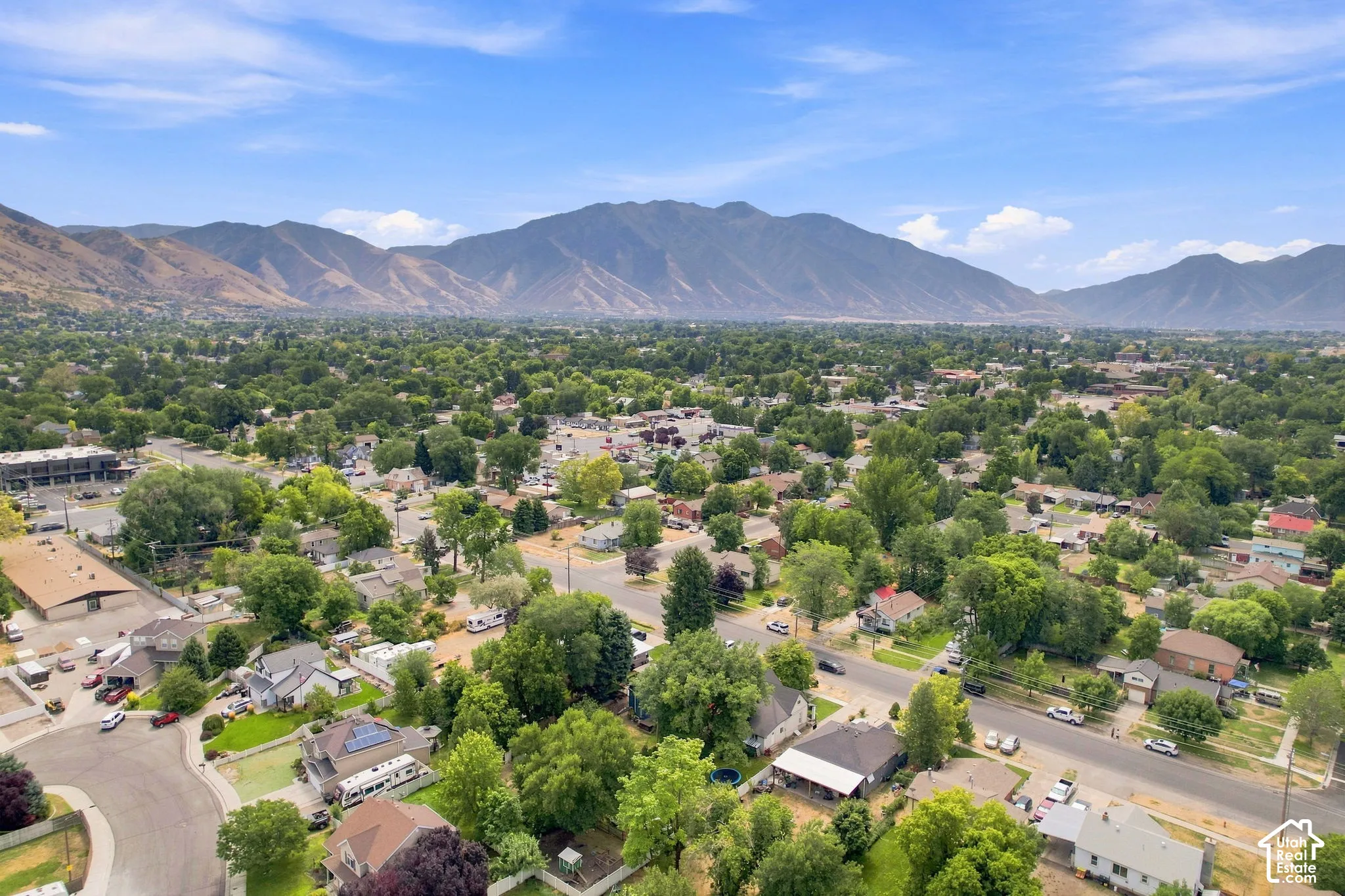 Expansive mountain backdrop, established neighborhood setting, mature tree canopy, varied architectural styles, and structured roadways