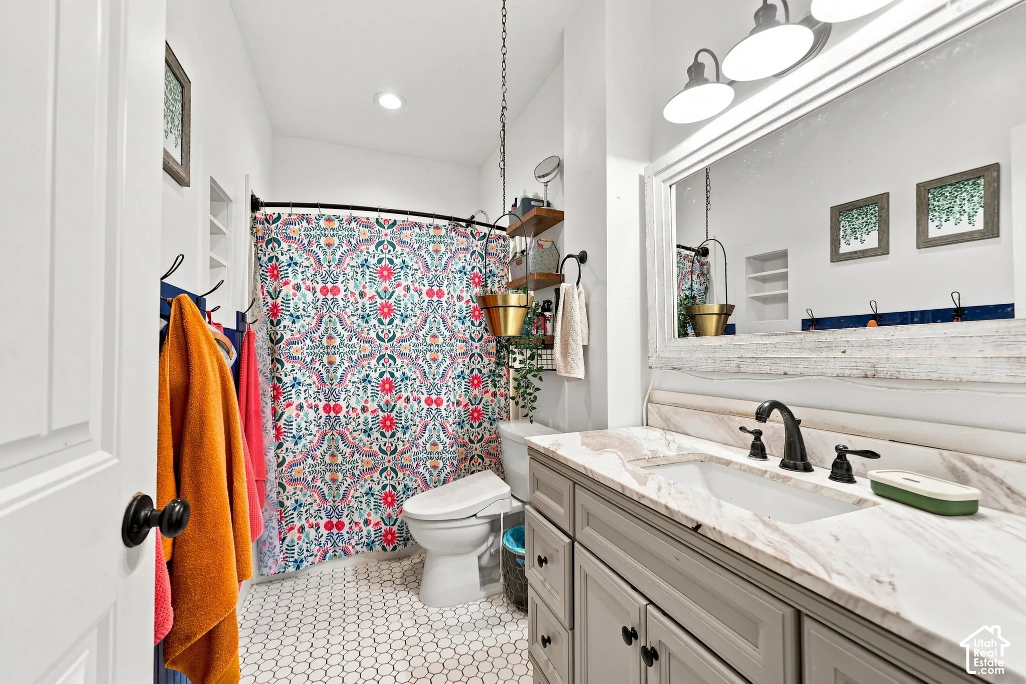 Vanity with an integrated sink, black hardware, and a stone countertop