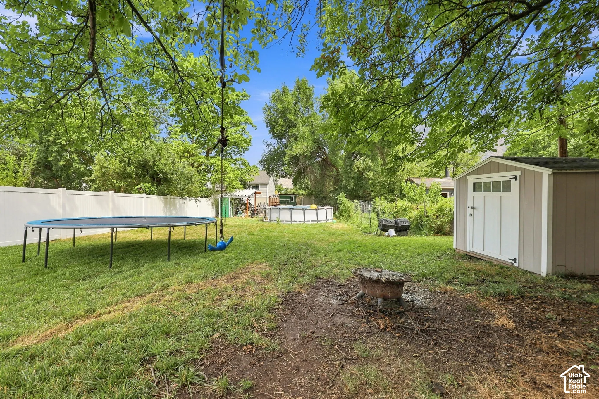 Expansive backyard with a storage shed, above-ground pool, and privacy fencing
