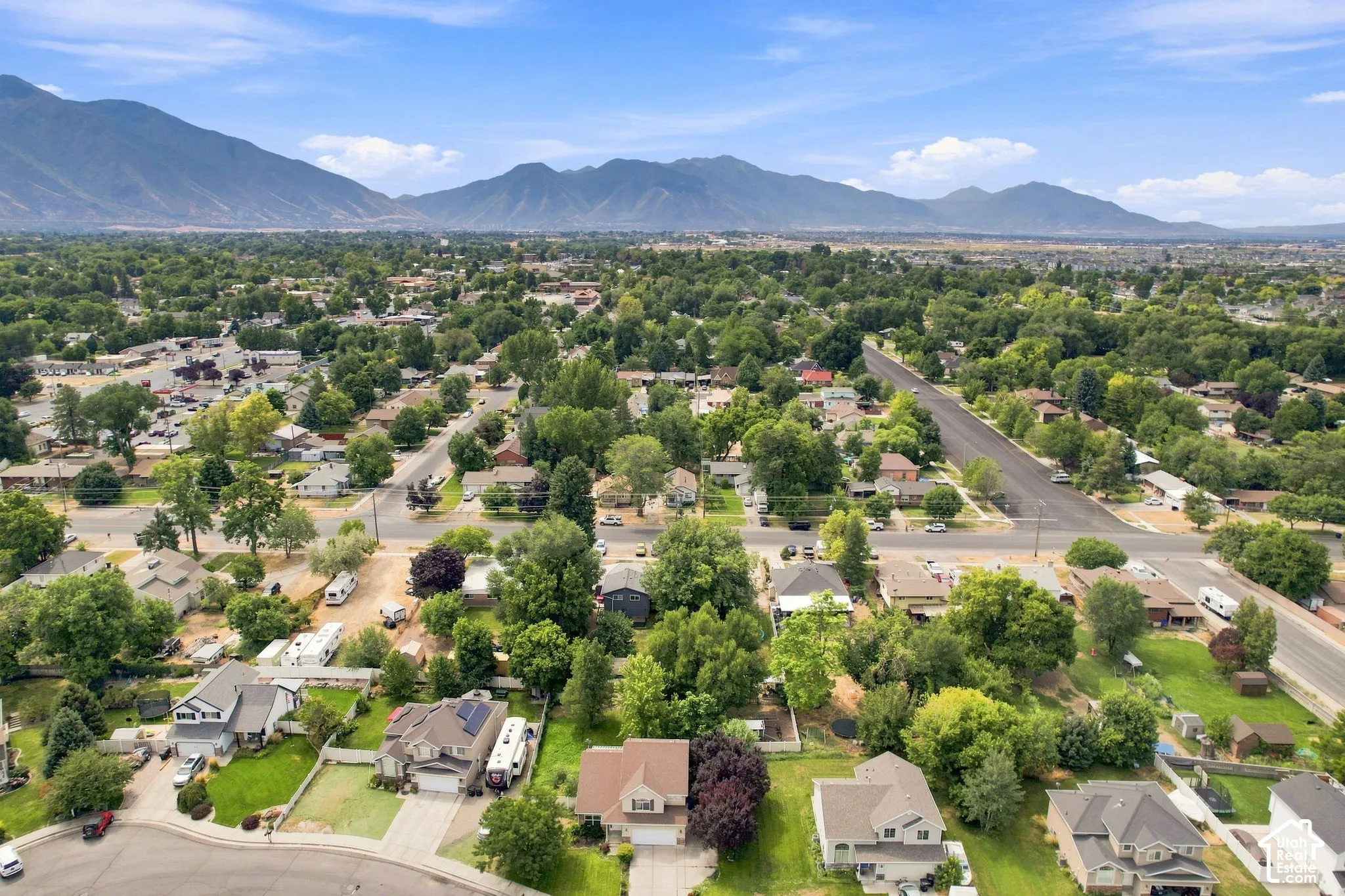 Expansive mountain backdrop with a residential area featuring mature trees and established streets