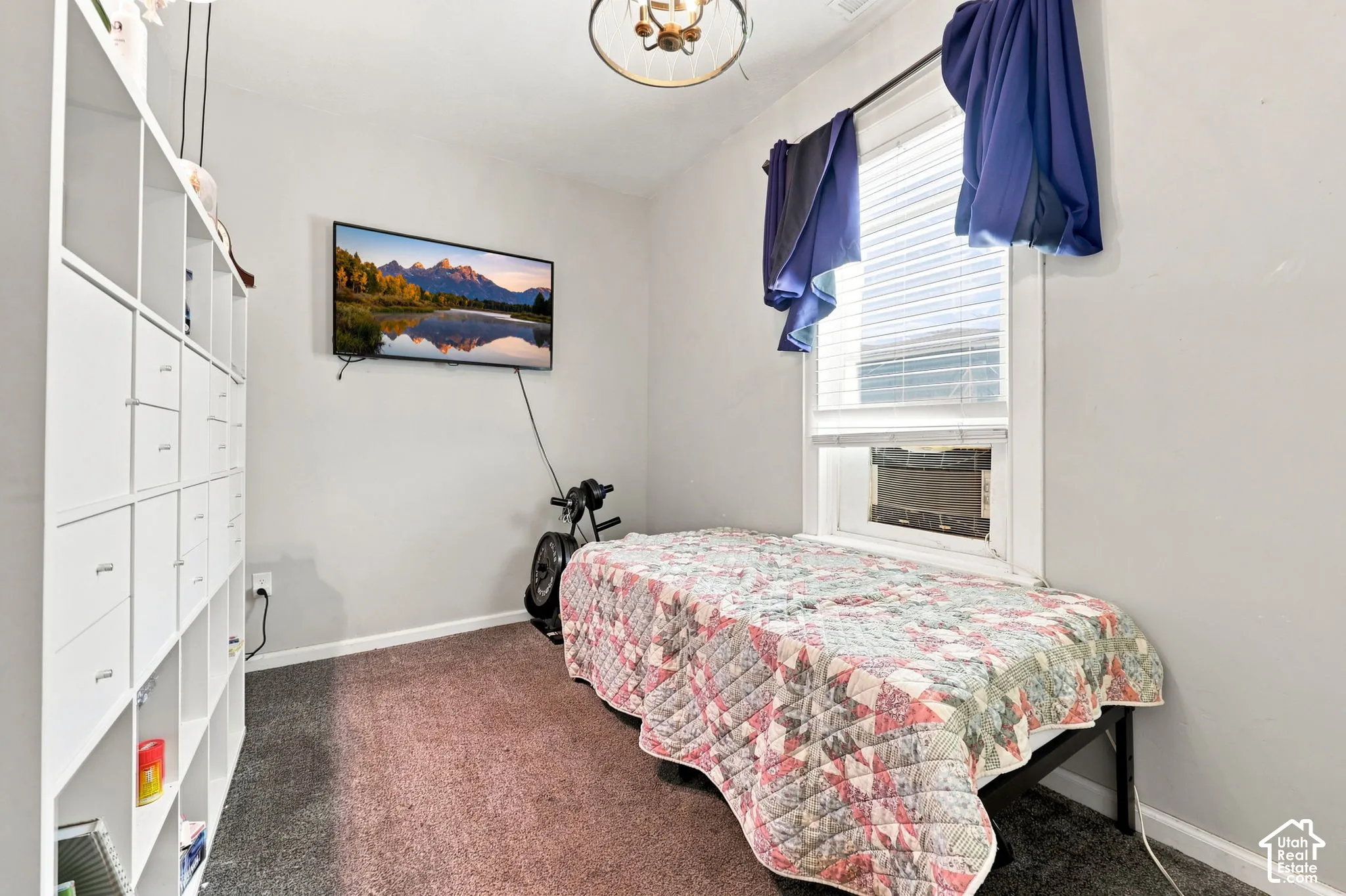 Wall-mounted shelving unit, wall-mounted television, and a window with blinds