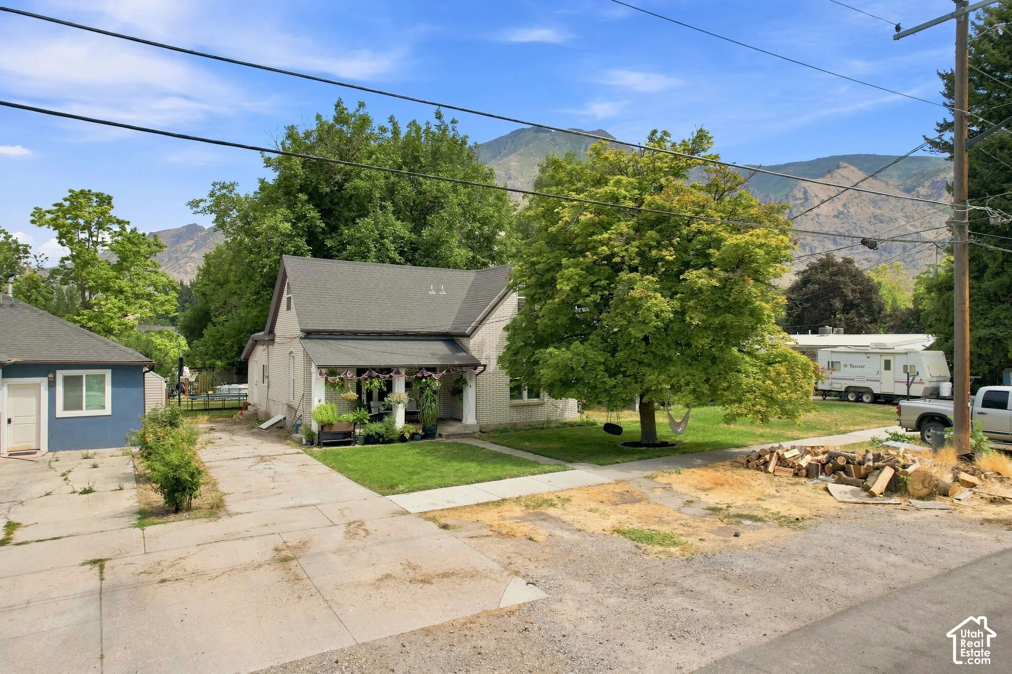 A-frame roofline residence with a covered porch, established front yard, and detached garage