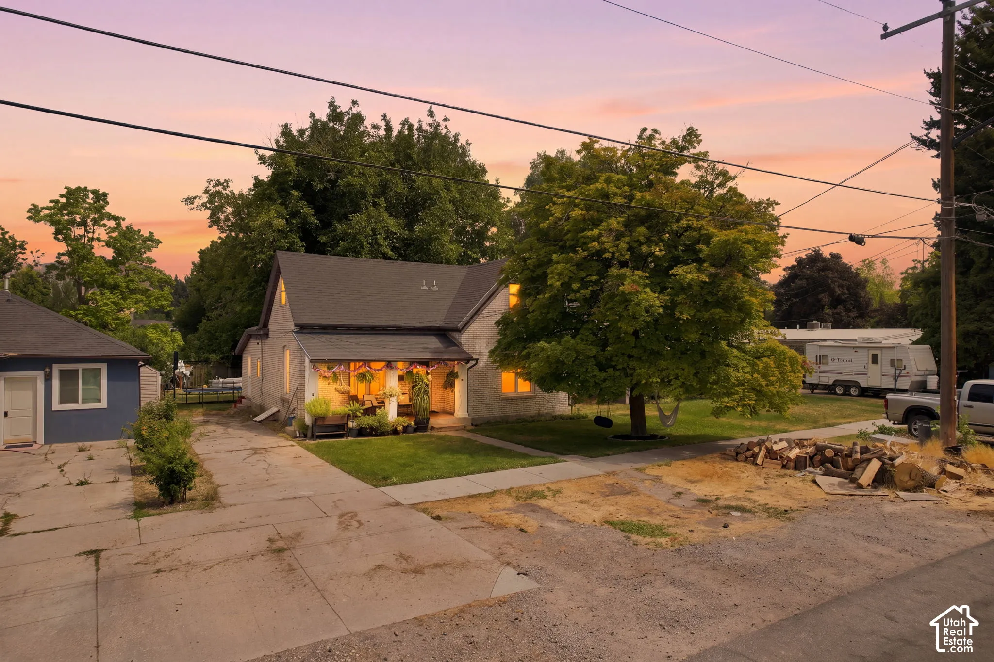 Durable roof shingles, covered front porch, detached outbuilding, mature landscaping, and concrete driveway