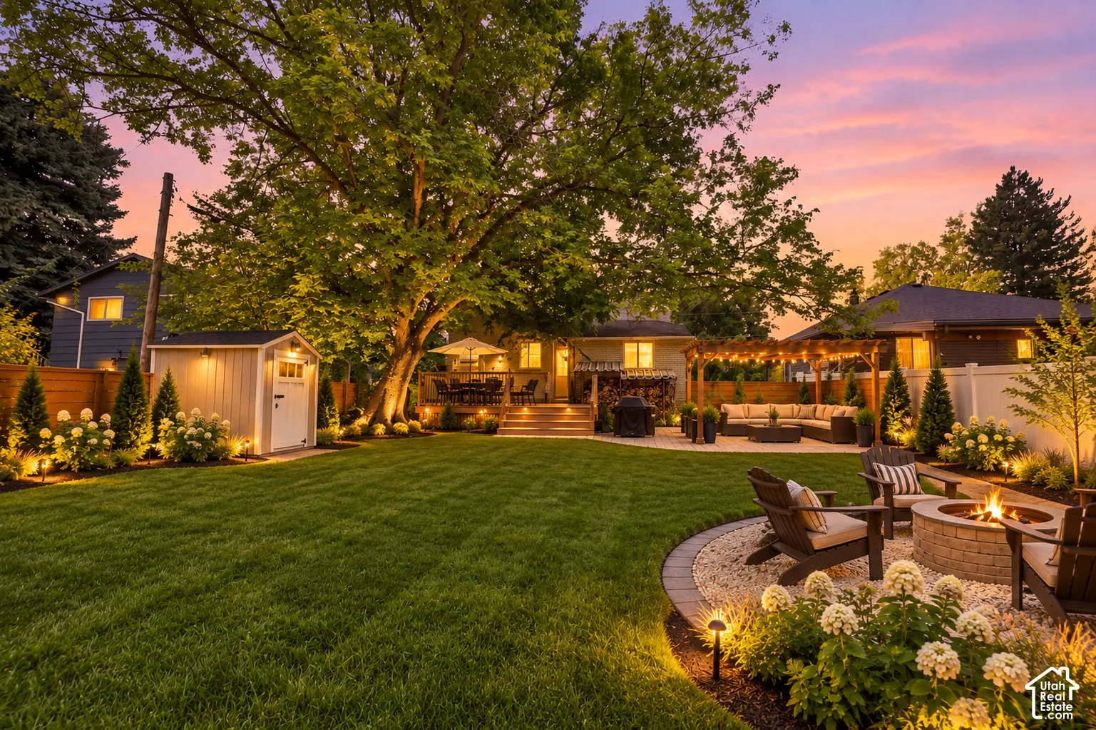 Expansive backyard with a manicured lawn, multiple paver patios, a built-in fire pit, and a detached storage shed