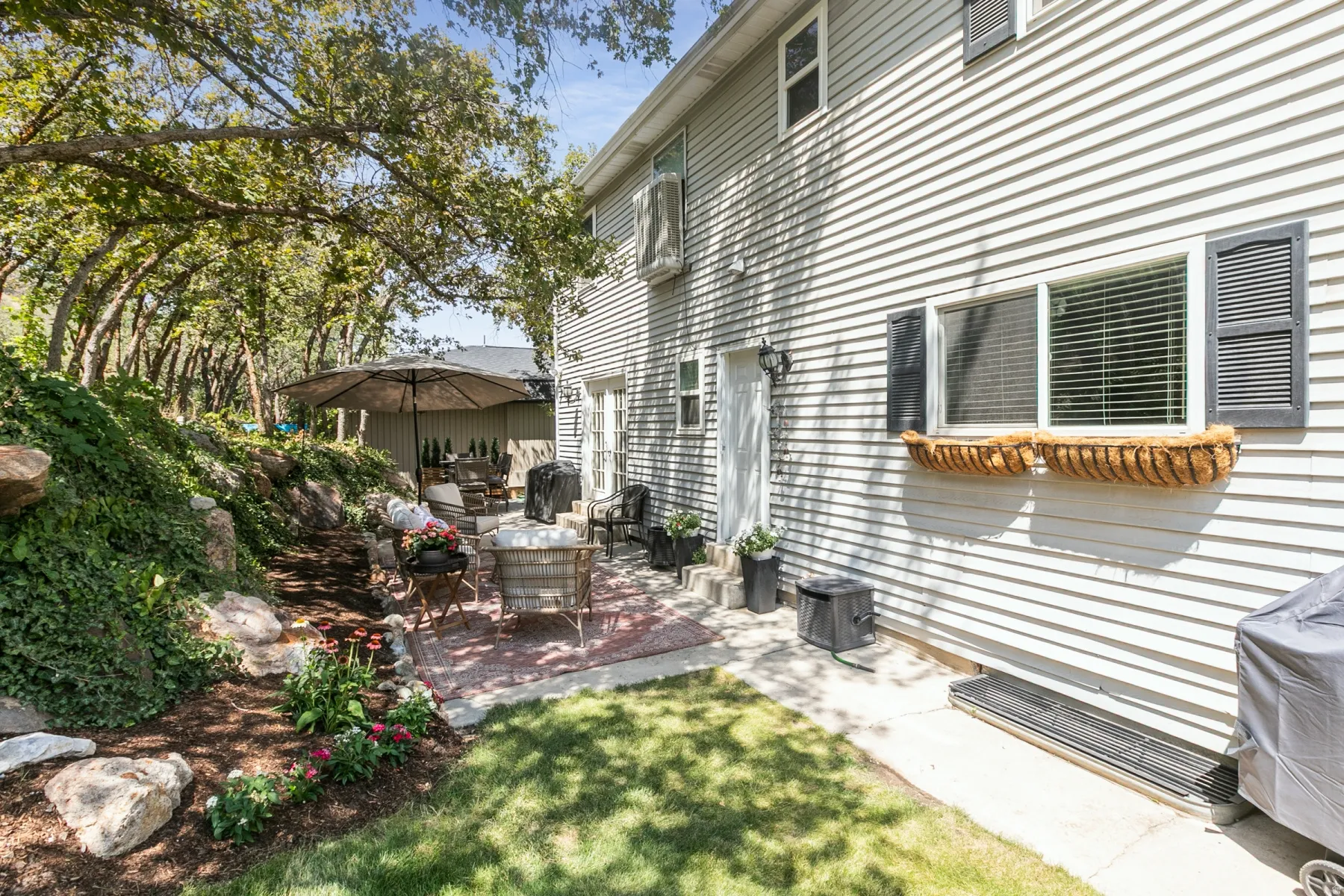 Siding exterior with decorative window shutters and a window planter box