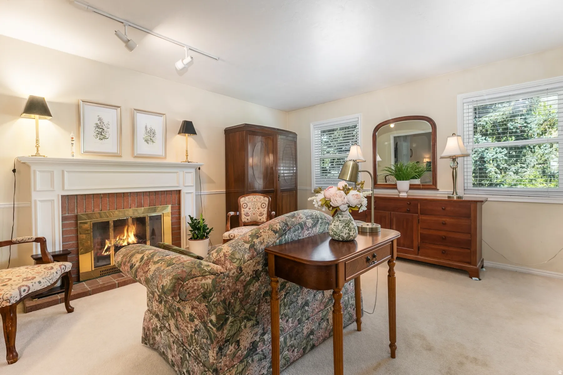 Elegant formal living room showcasing a working fireplace with decorative surround, hardwood flooring, and recessed lighting