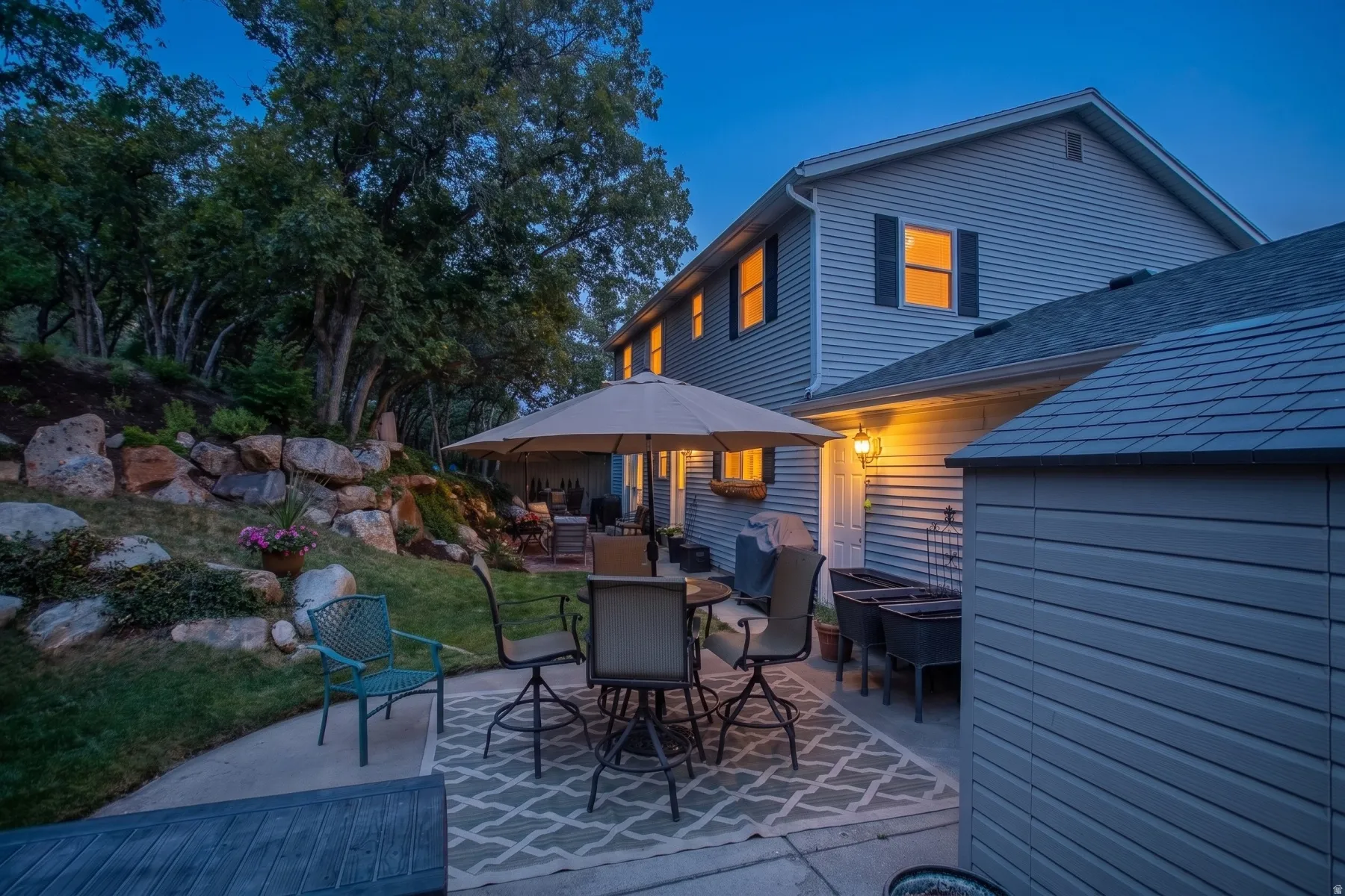 Hardscaping with a concrete patio, retaining wall, and mature landscaping