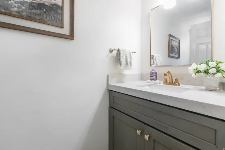 Vanity featuring a stone countertop, an undermount sink, and a gold-tone faucet