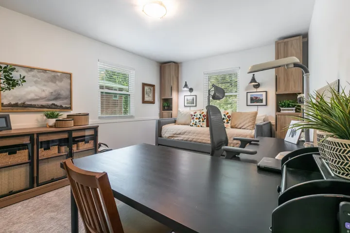 Recessed ceiling lighting, two windows with blinds, built-in shelving, and wall sconces