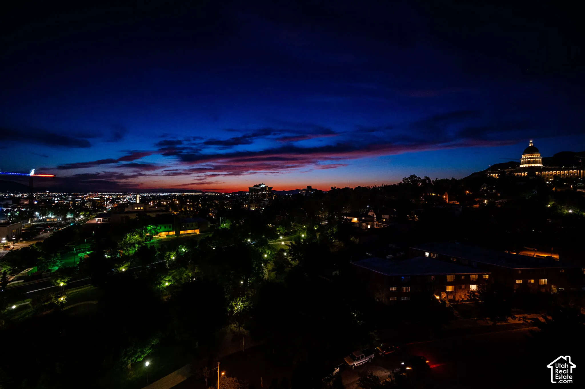 Additional contentThe image shows an elevated nighttime cityscape with architectural lighting and a twilight sky