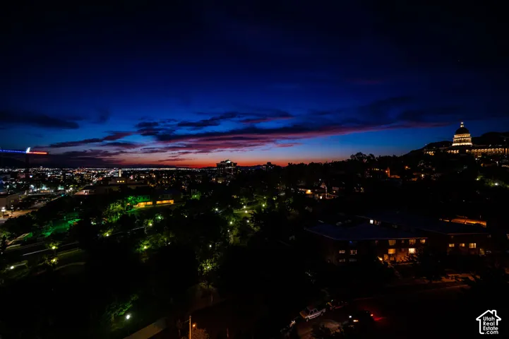 Additional contentThe image shows an elevated nighttime cityscape with architectural lighting and a twilight sky