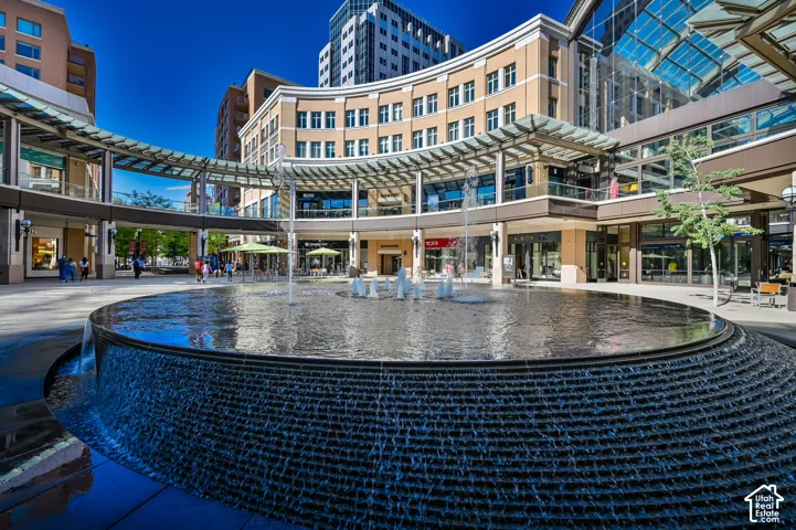 Circular water feature with multiple fountains and a cascading edge