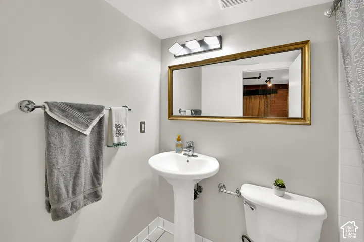 Clean and functional full bath featuring a pedestal sink with chrome fixtures, white ceramic toilet, and recessed lighting