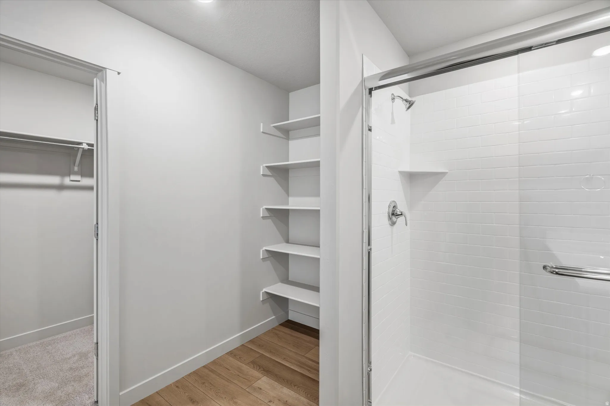 Walk-in shower with subway tile surround and glass enclosure