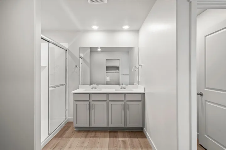 Double vanity with white countertop, chrome fixtures, and grey cabinetry