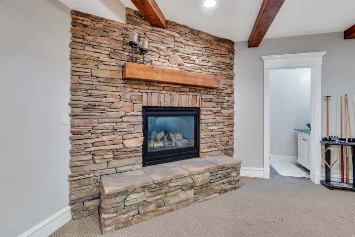 Stone-clad fireplace with a wood mantel and hearth.