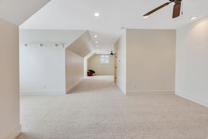 Carpeted flooring, recessed lighting, ceiling fan, and sloped ceilings.