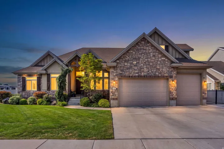 Twilight view of this beautiful home with custom roof lines, 3 car garage and beautiful landscaping.