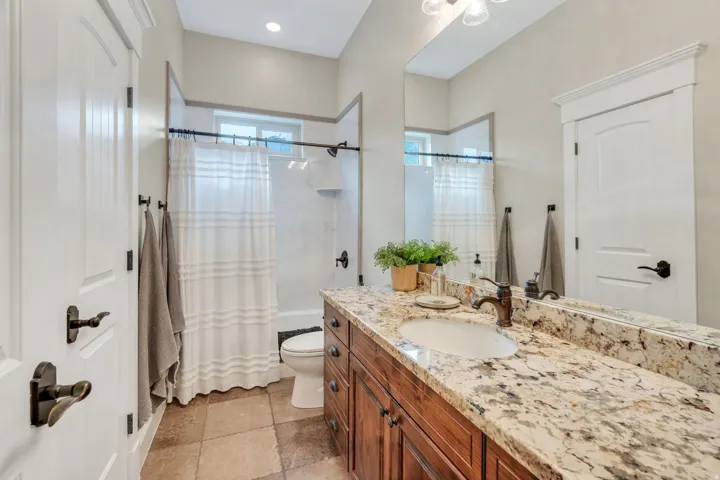 Vanity with an integrated sink, granite countertop, and wood-finish cabinetry.
