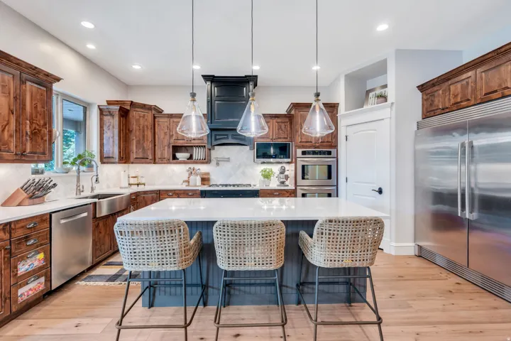 Spacious kitchen featuring a large center island with counter seating,  and custom pendant lighting.