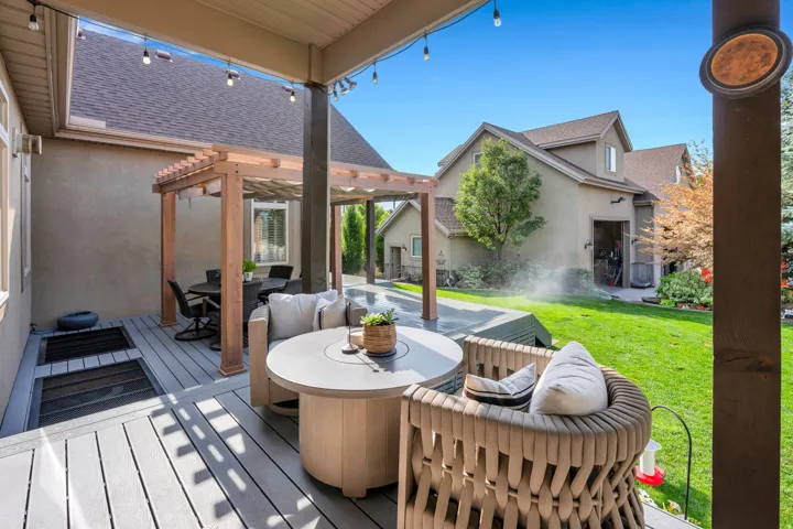 Expansive outdoor living area featuring a covered patio, composite decking, and a wood pergola.