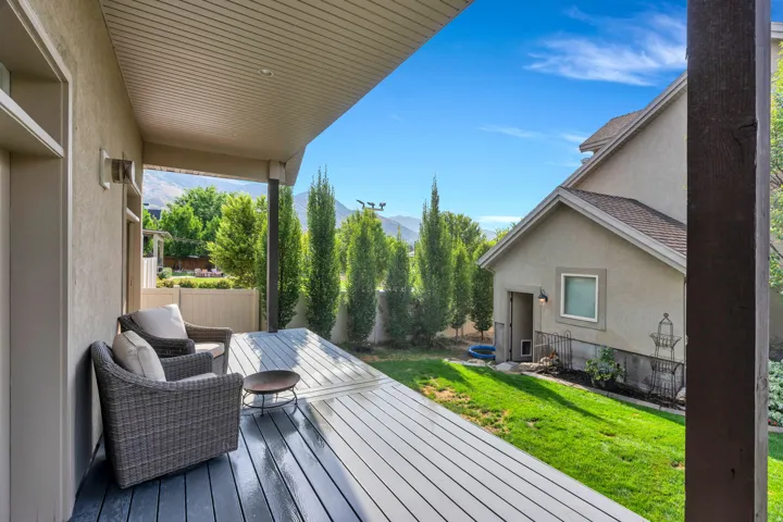 Covered patio featuring a composite deck, recessed lighting, and exterior wall sconces.
